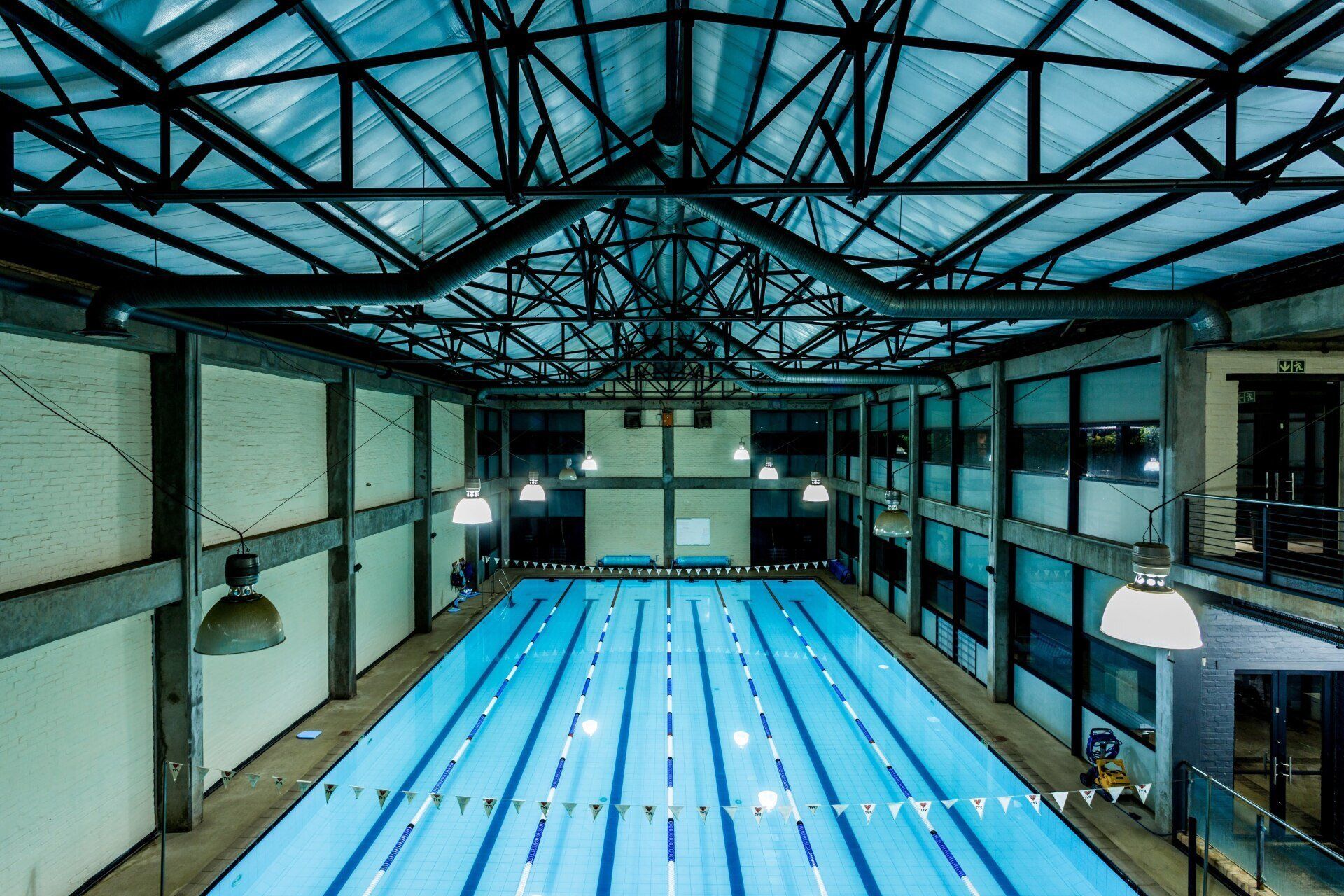 A large indoor swimming pool with a glass roof