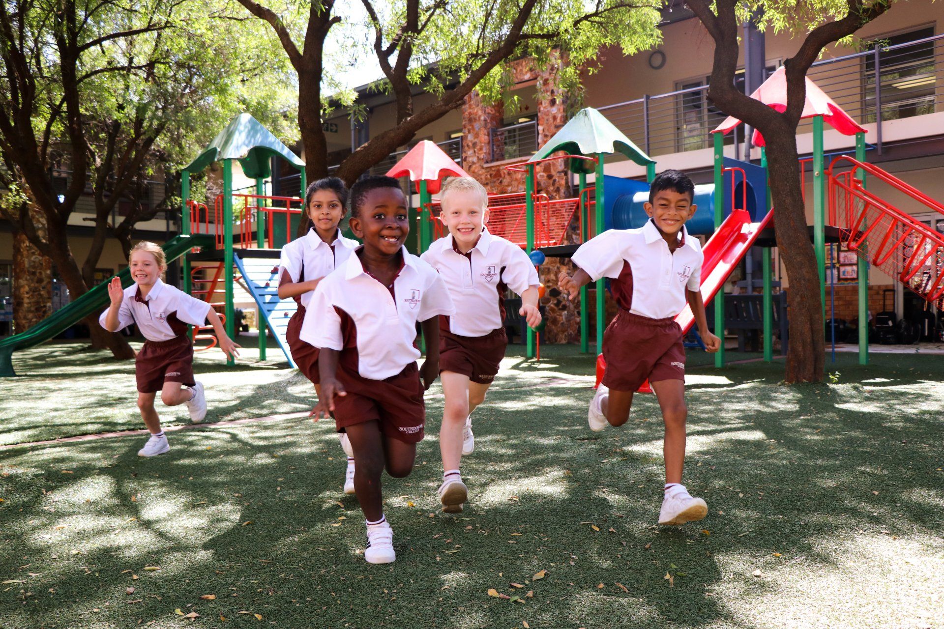 A group of children are running in a playground.