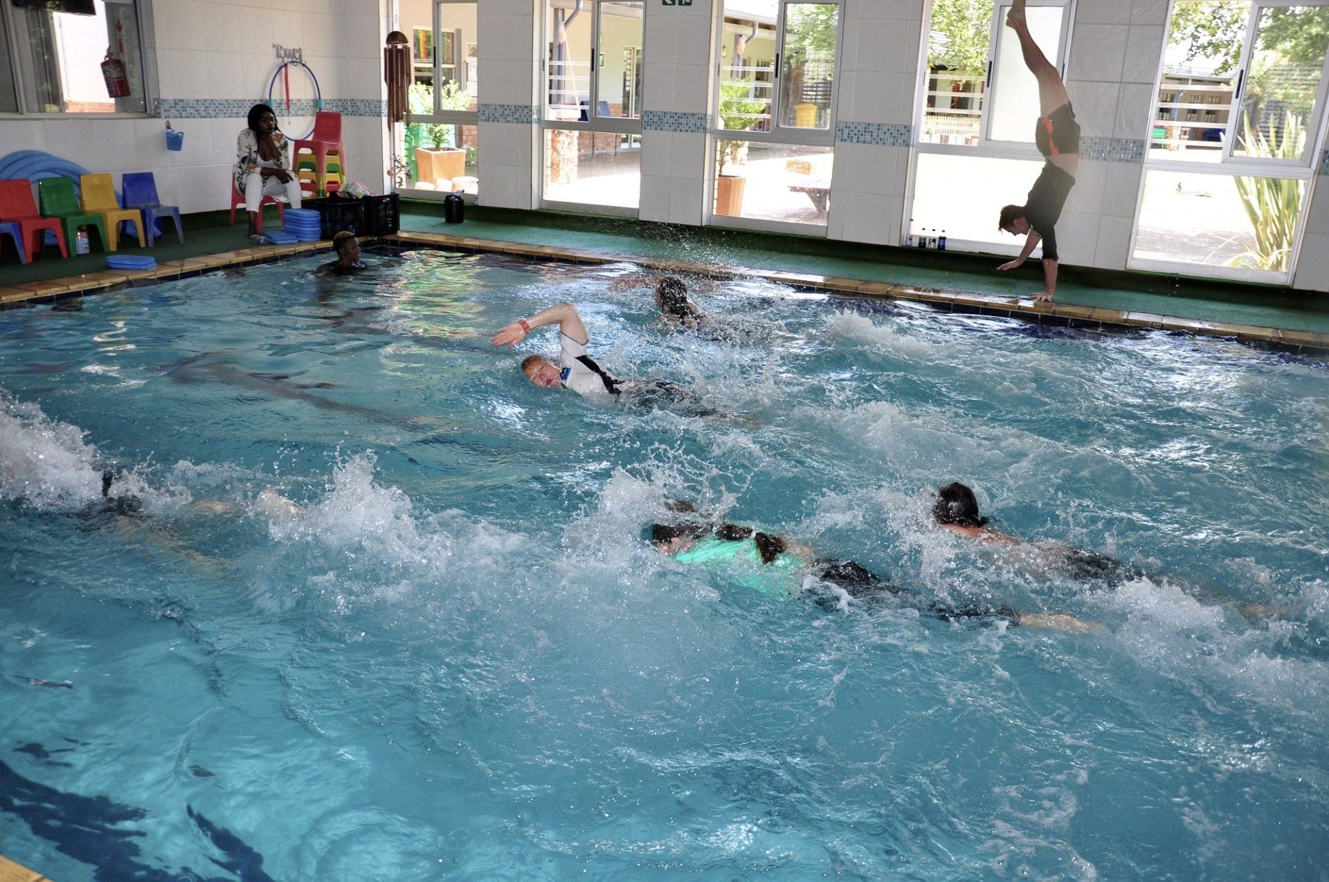 A group of people are swimming in a swimming pool