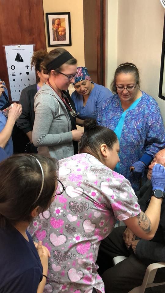 A group of nurses are standing around a patient in an operating room.