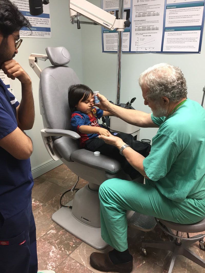 A dentist is examining a child in a dental chair