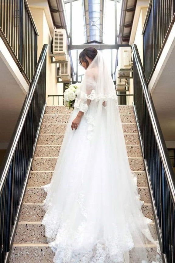 A Bride in a Wedding Dress And Set of Stairs Holding a Bouquet of Flowers — Eternal Weddings & Couture In Woolner, NT