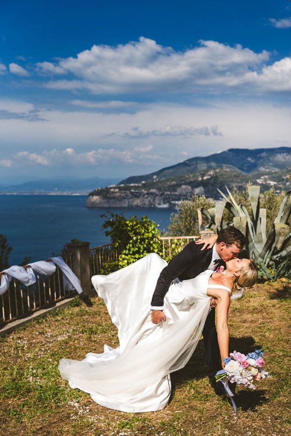 A Bride and Groom Are Kissing in Front of a View of the Ocean — Eternal Weddings & Couture In Woolner, NT