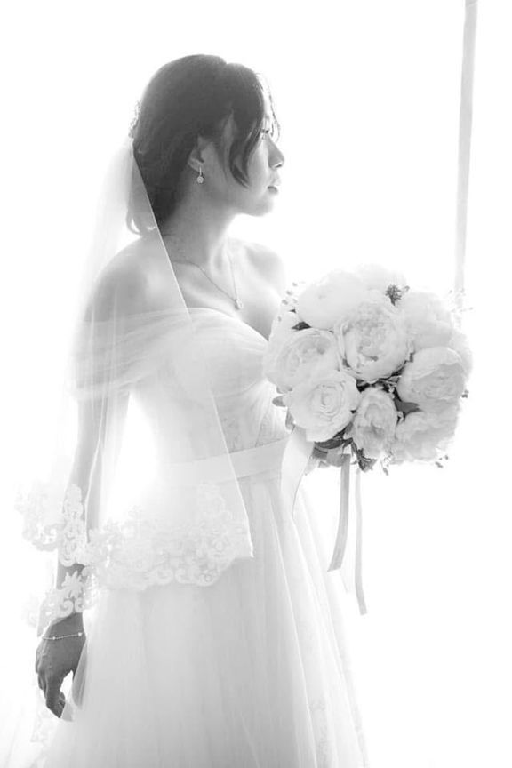 A Bride in a Wedding Dress Holding a Bouquet of Flowers — Eternal Weddings & Couture In Woolner, NT