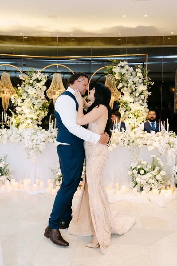 A Bride and Groom Are Kissing on the Dance Floor at Their Wedding Reception — Eternal Weddings & Couture In Woolner, NT