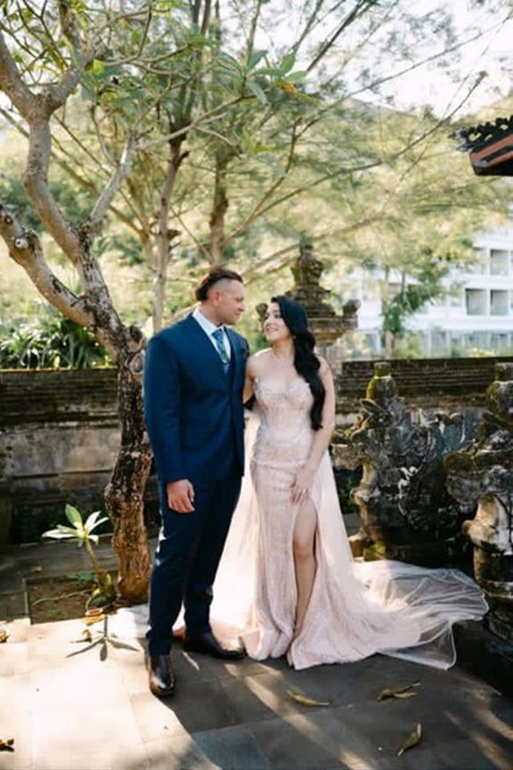 A Bride and Groom Are Standing Next to Each Other in Front of a Tree — Eternal Weddings & Couture In Woolner, NT