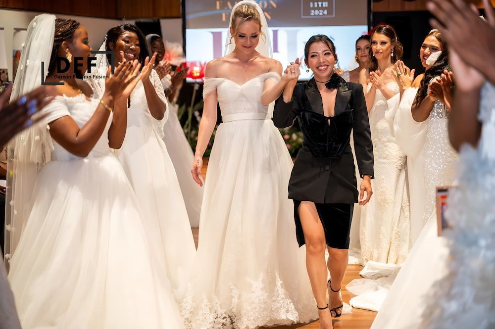 A Woman in a Wedding Dress is Walking Down the Runway at a Wedding Show — Eternal Weddings & Couture In Woolner, NT