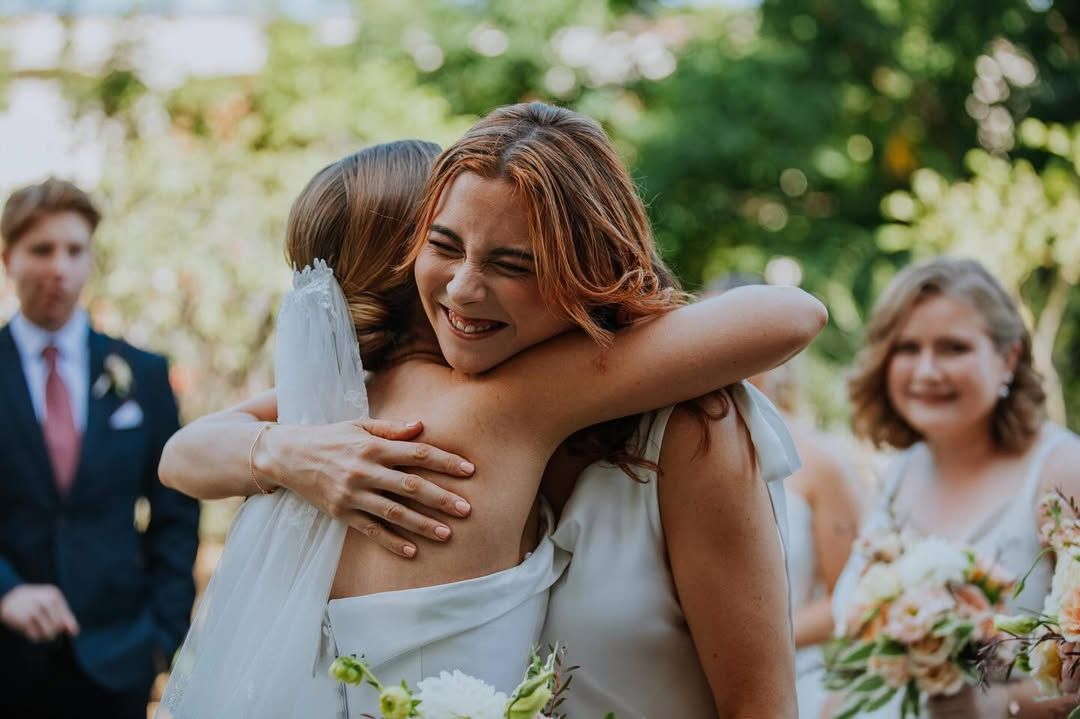 Two Women Are Hugging Each Other At A Wedding Ceremony — Eternal Weddings & Couture In Woolner, NT