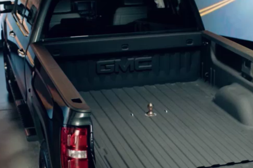 A black gmc truck is parked in a showroom