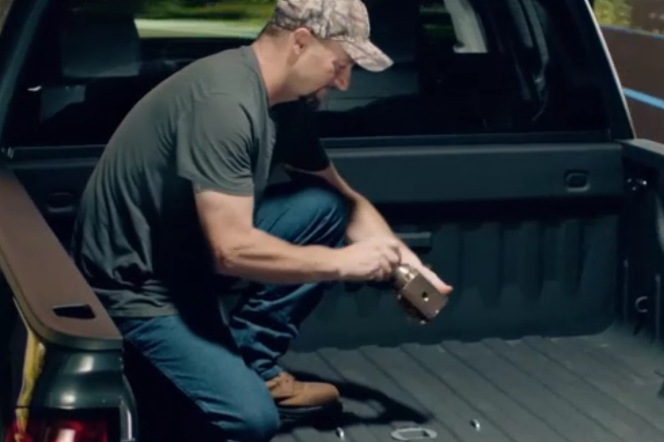 A man is kneeling in the back of a truck