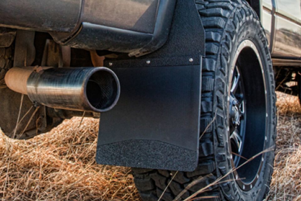 A close up of a truck with mud flaps and a exhaust pipe.