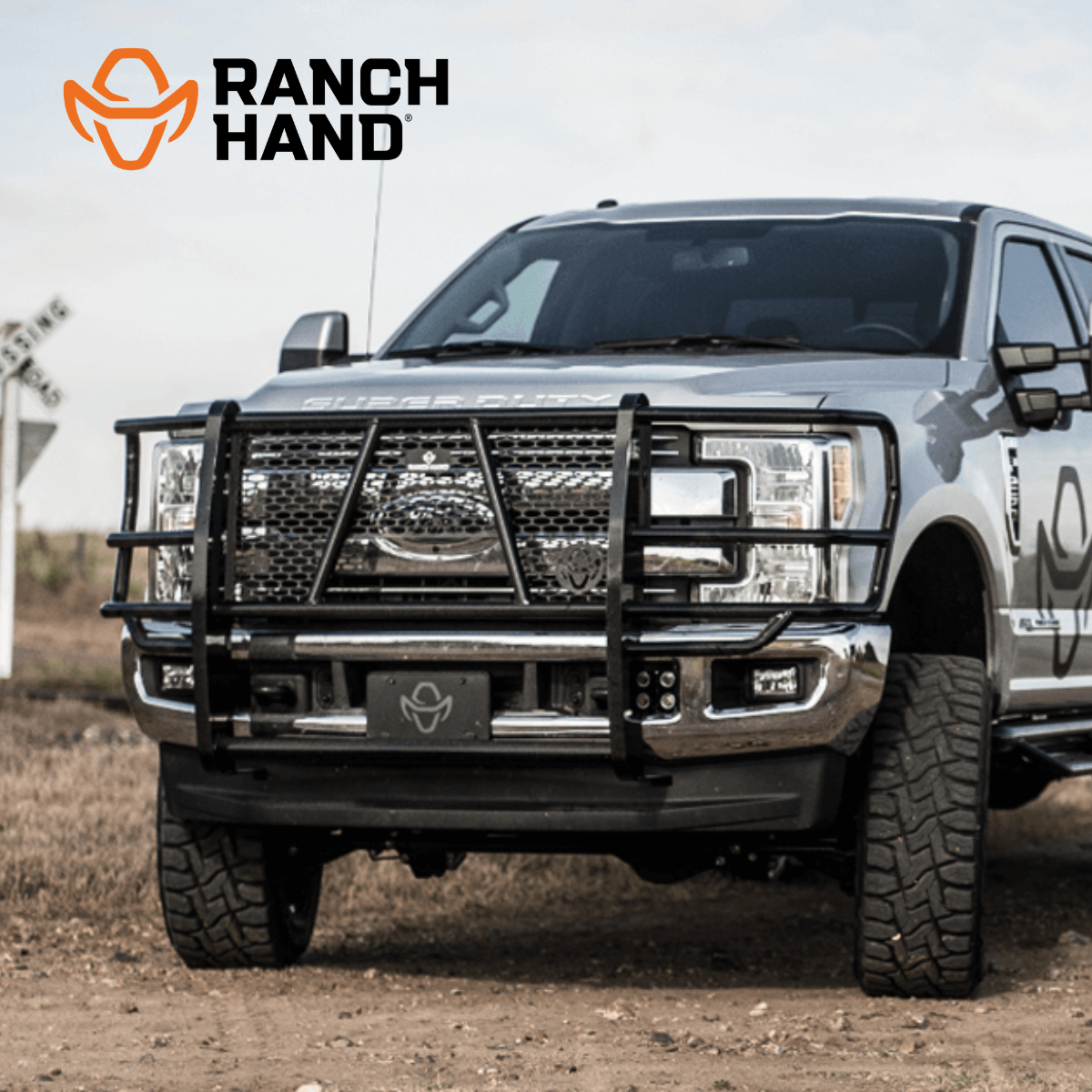 A ranch hand truck is parked in a dirt field