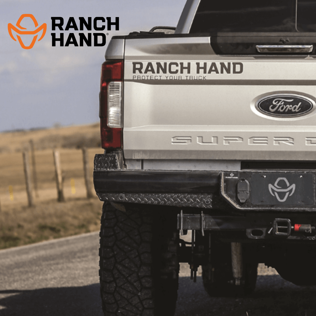 A silver ford truck with ranch hand written on the tailgate