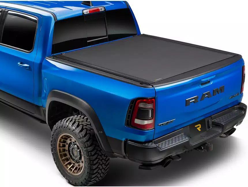 A blue ram truck with a black bed cover on it.