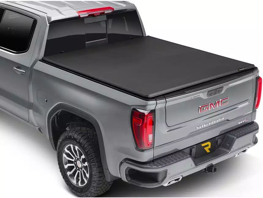 A gray truck with a black tonneau cover on the bed.