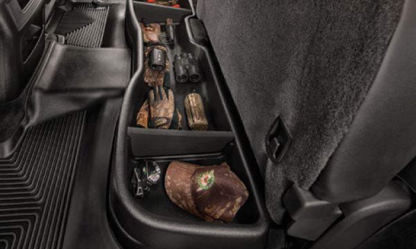 A trunk organizer in the back seat of a car filled with various items.