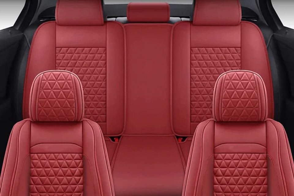 The back seat of a car with red leather seats.