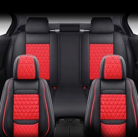 The back seat of a car with red and black seats.