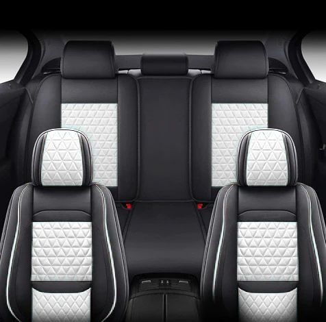 The back seat of a car with black and white seats.