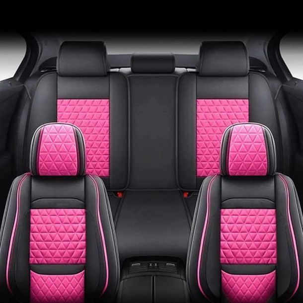 The back seat of a car with pink seat covers.