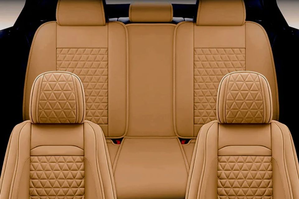 The back seat of a car with brown seat covers and headrests.