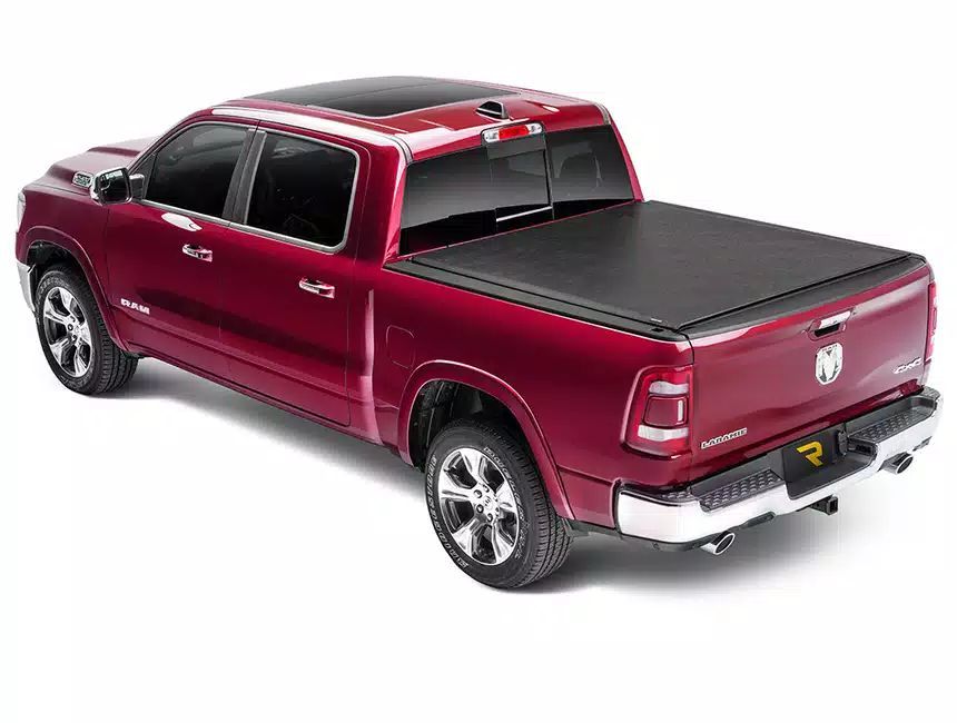 A red dodge ram truck with a black tonneau cover on the bed.