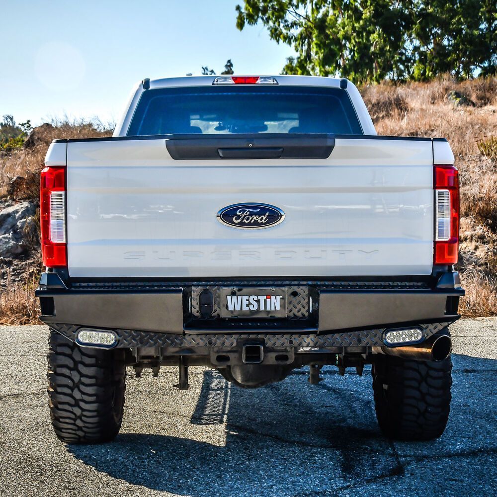 A white ford truck is parked on the side of the road