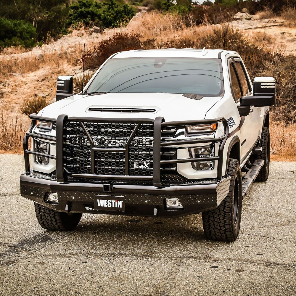 A white truck with a black bumper is parked on the side of the road.