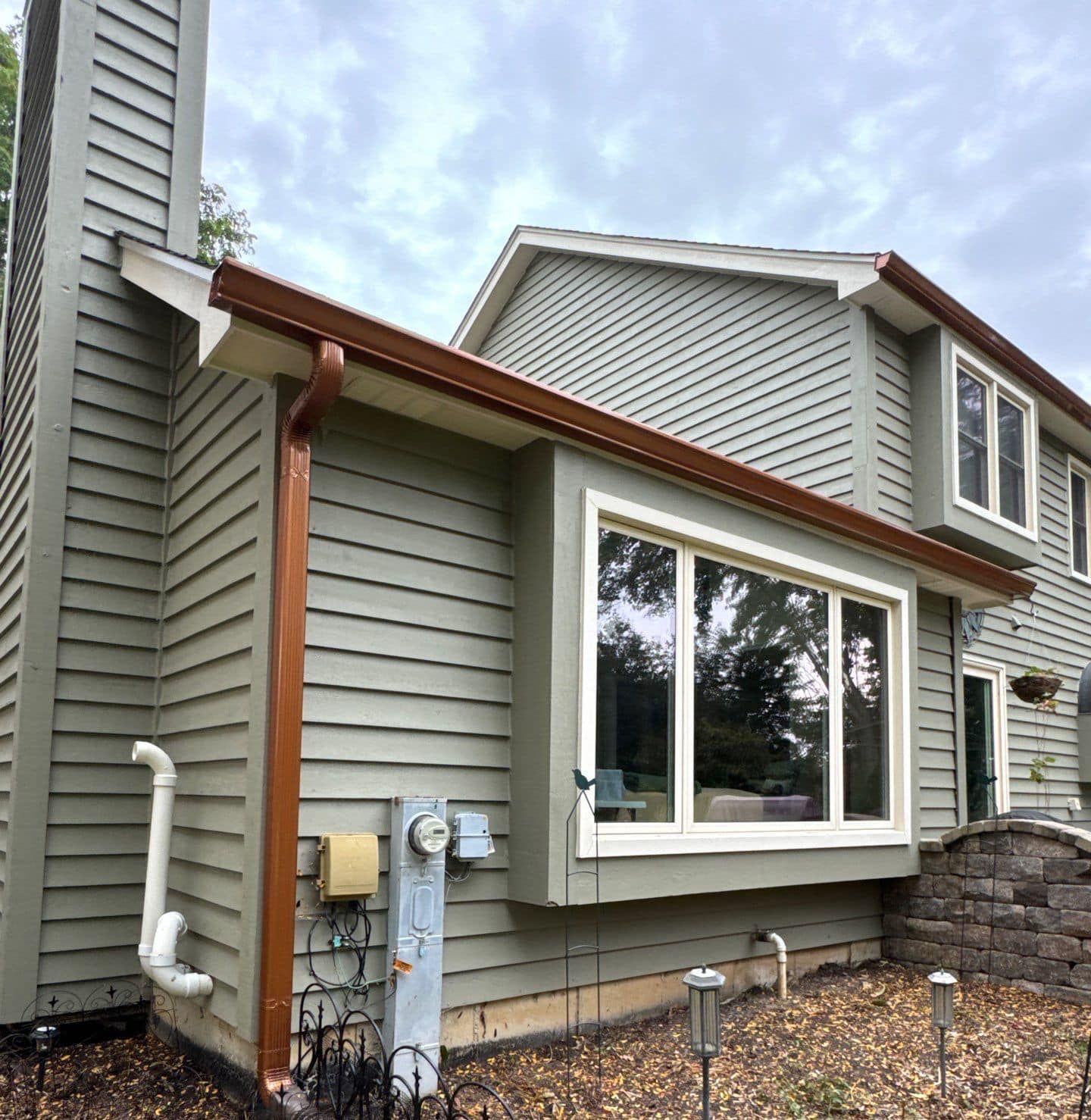 A house with a large window and a brown gutter