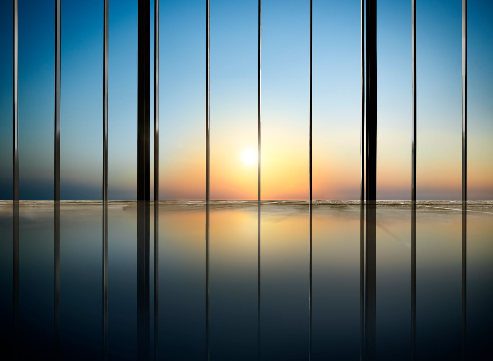 O sol é refletido na água através das janelas de um edifício.