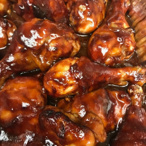 Glazed barbecue chicken drumsticks with a glossy brown sauce, close-up