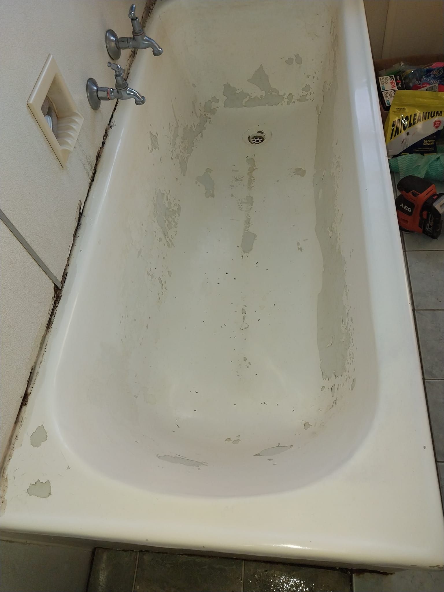 A White Bathtub Is Sitting In A Bathroom Next To A Wall — McCarthys Property Services in Glenugie, NSW