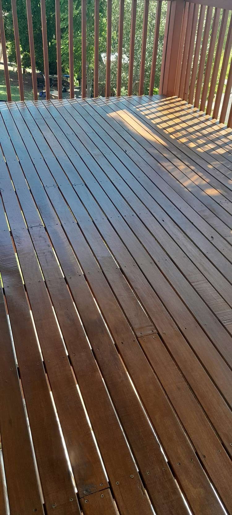 A Close Up Of A Wooden Deck With A Railing — McCarthys Property Services in Grafton, NSW