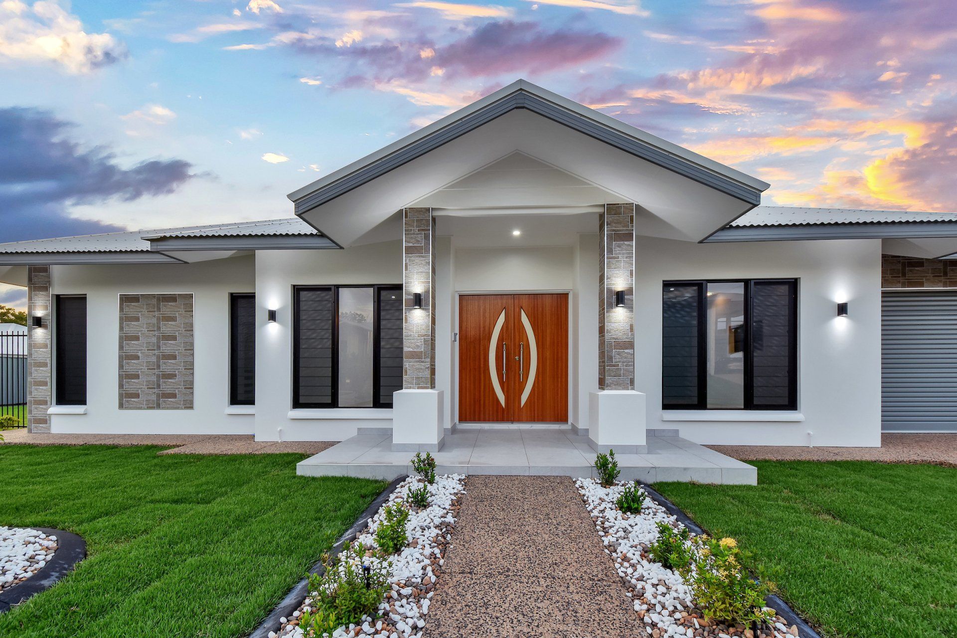 A large white house with a red door and a walkway leading to it.