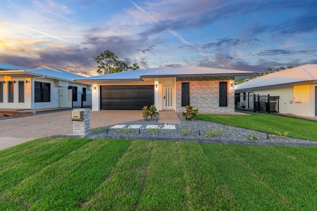 An empty living room with a ceiling fan and a stone wall.