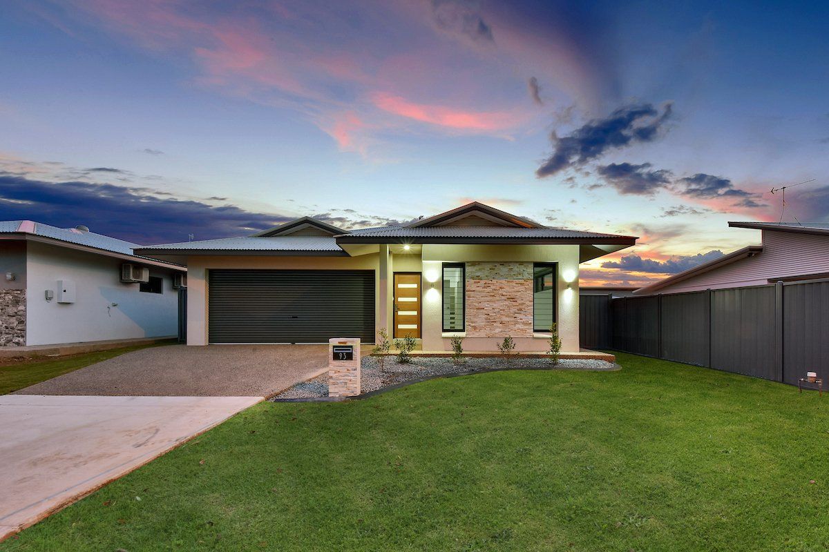 A house with a large lawn in front of it and a garage.