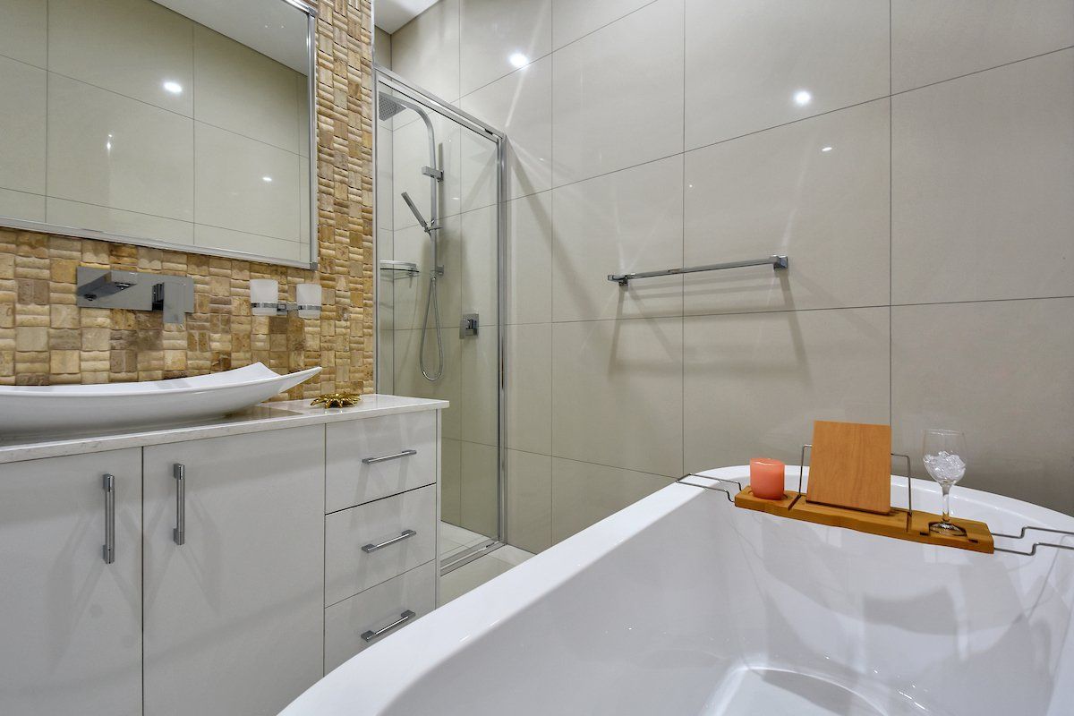 A bathroom with a bathtub , sink and shower.