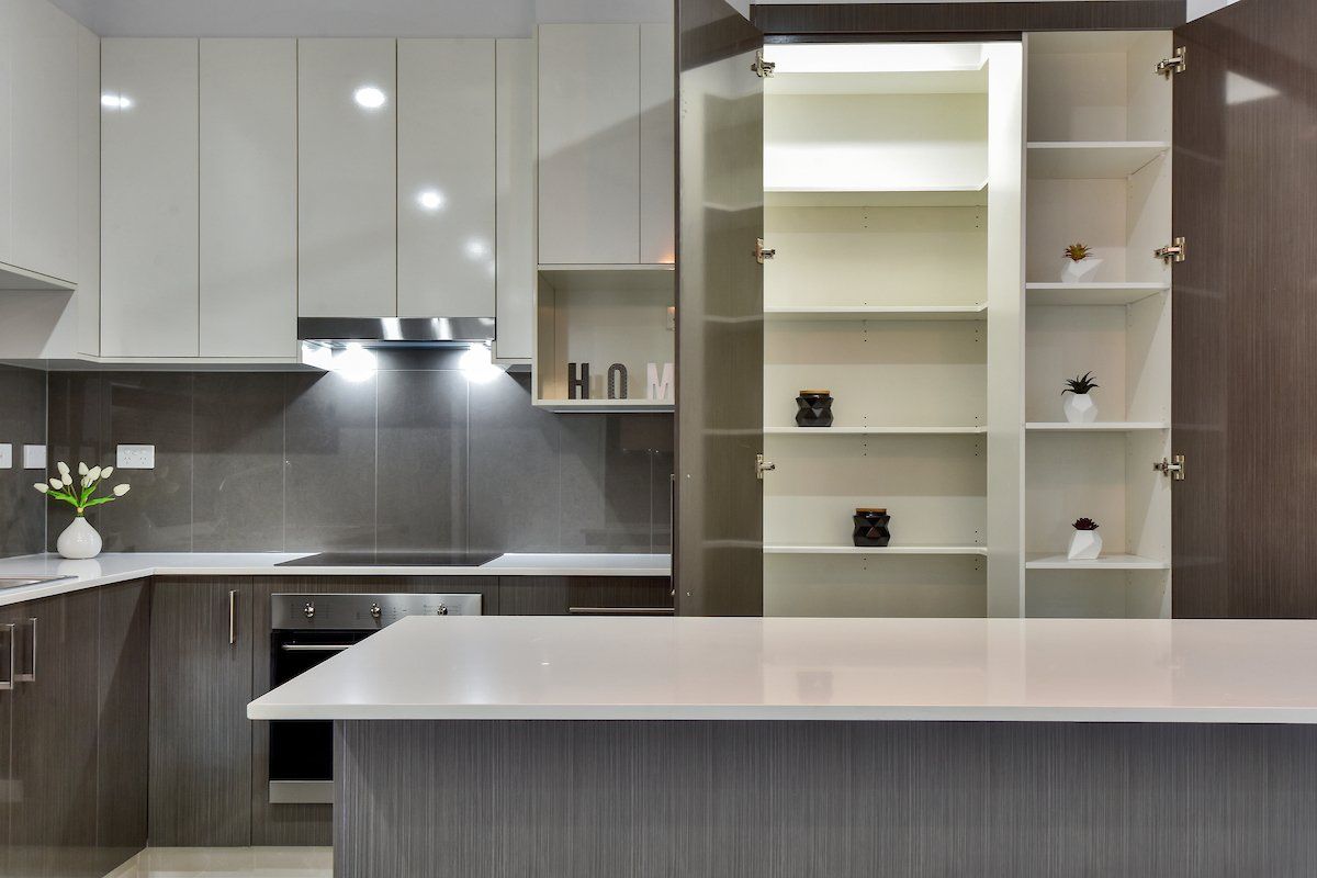 A kitchen with white cabinets and a white counter top