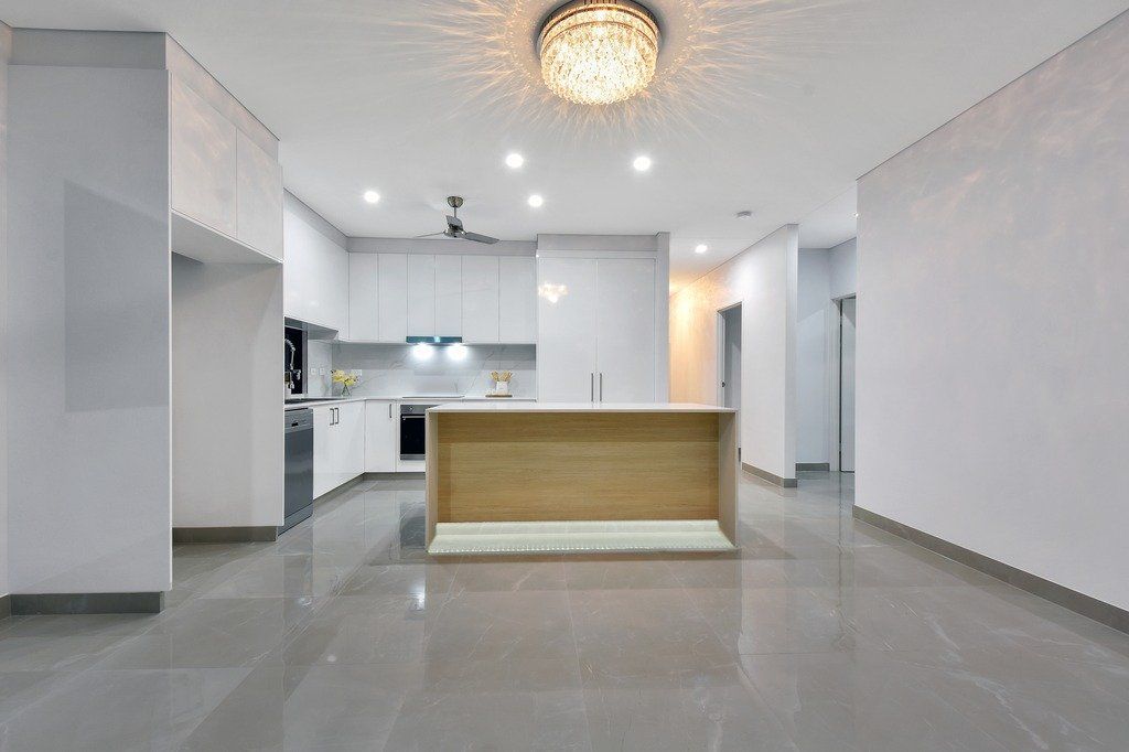 An empty kitchen with a large island in the middle of the room.