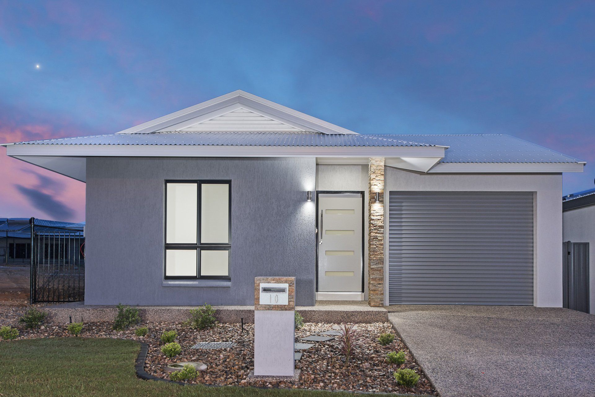 A house with a garage and a mailbox in front of it