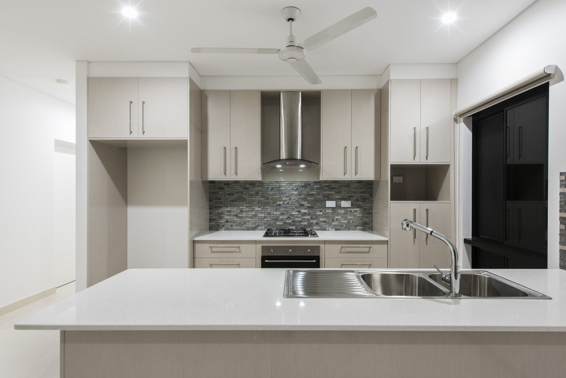 A kitchen with stainless steel appliances and a ceiling fan