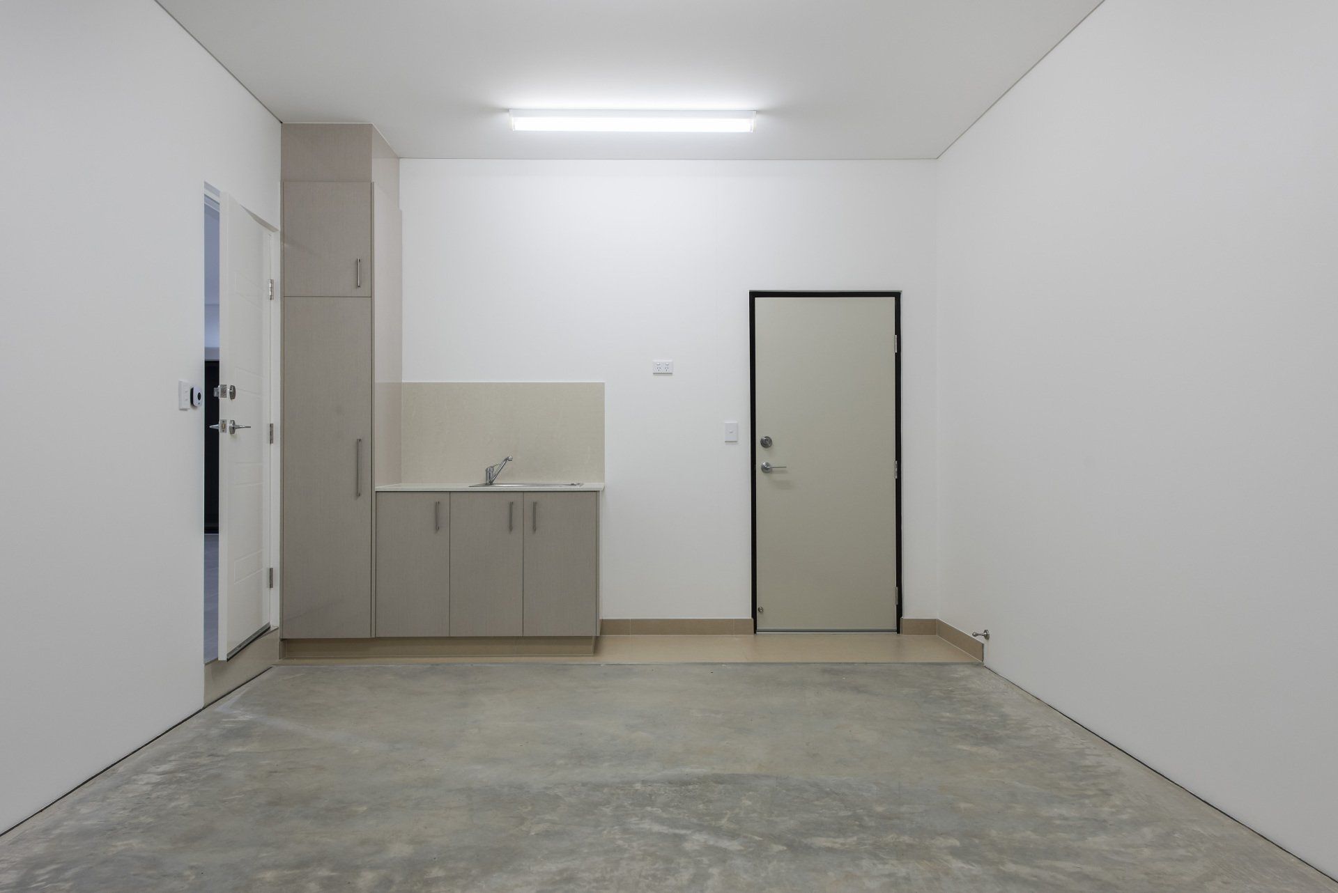 An empty room with white walls and a door