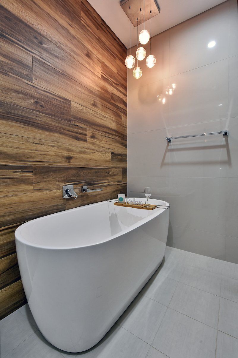 A bathroom with a bathtub and a wooden wall.