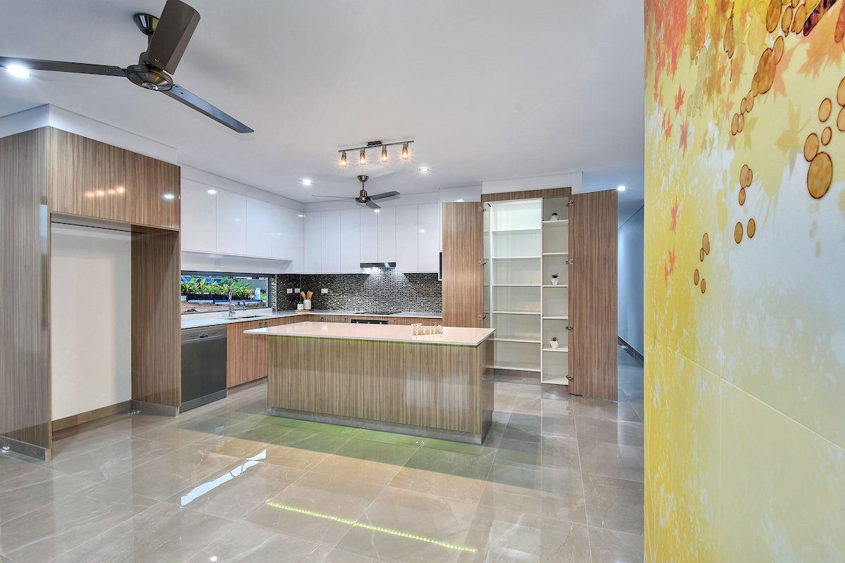 A kitchen with a large island and a ceiling fan.