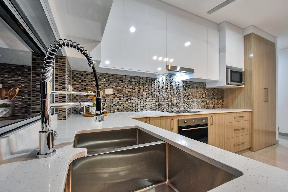 A kitchen with a stainless steel sink and a faucet.