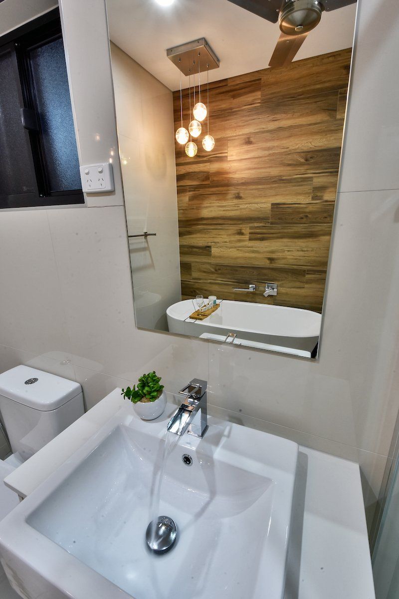 A bathroom with a sink , toilet , tub and mirror.