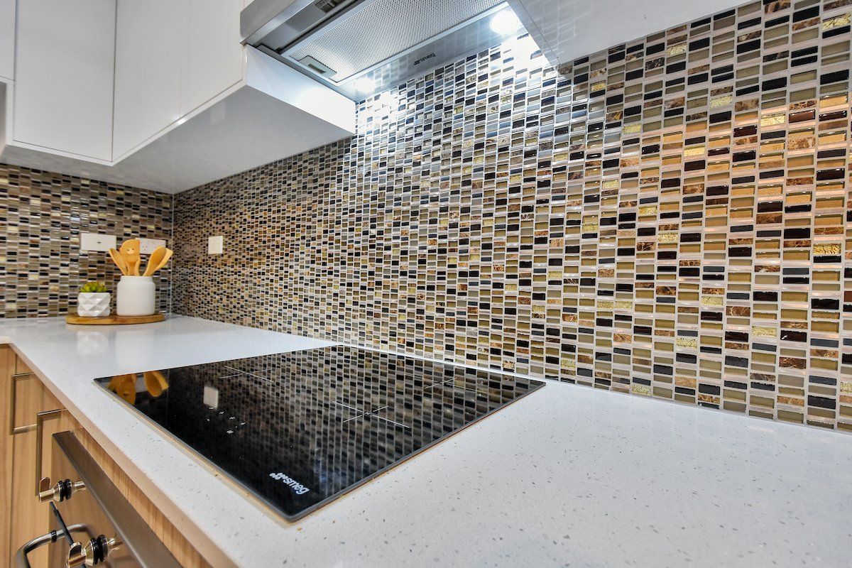 A kitchen with a stove top oven and a hood.