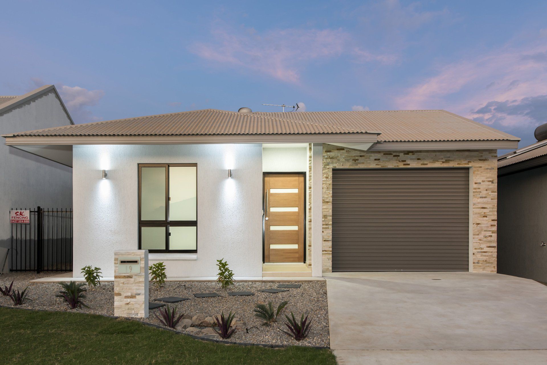 A white house with a gray garage door and a brown door