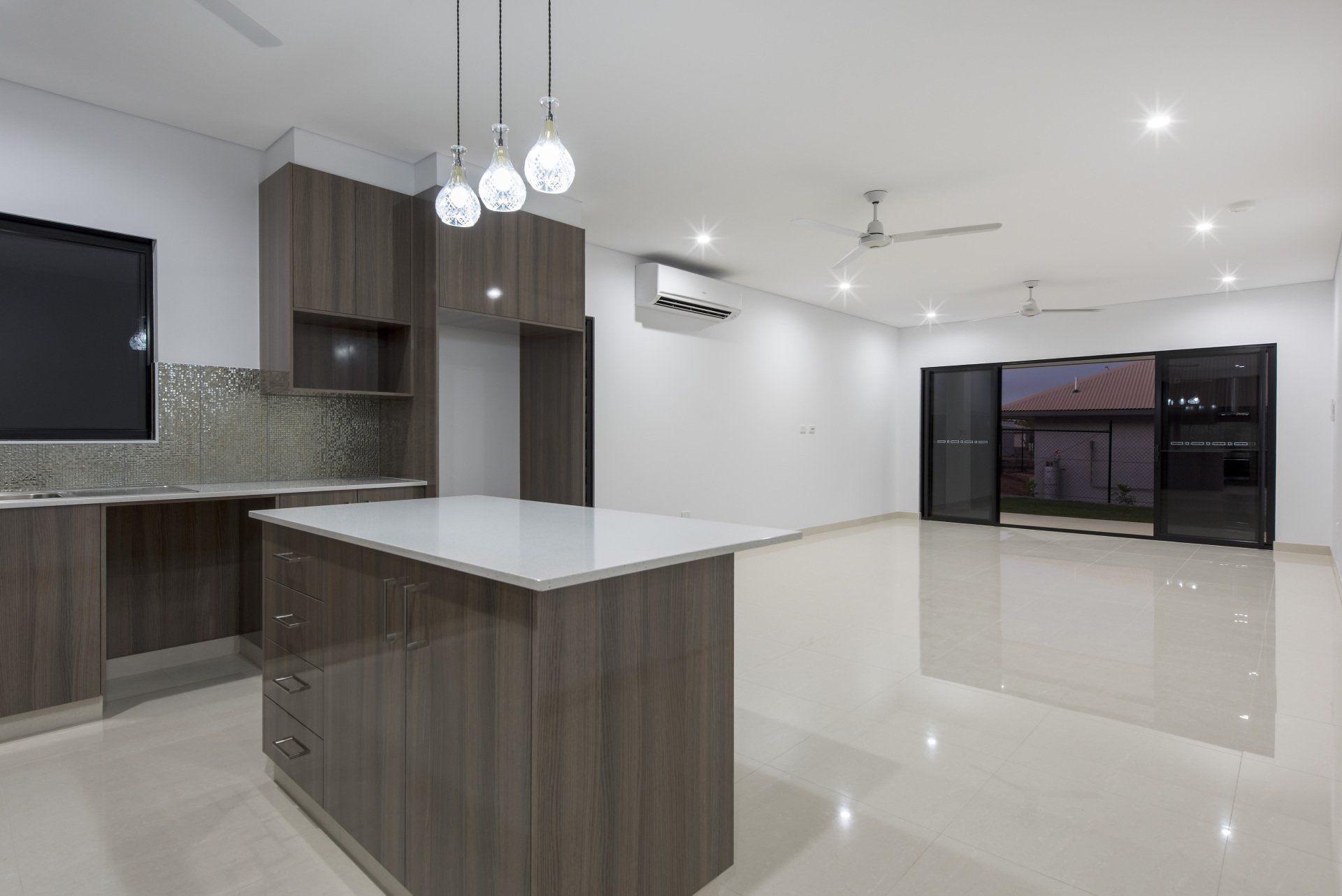 An empty kitchen with a large island in the middle of the room.