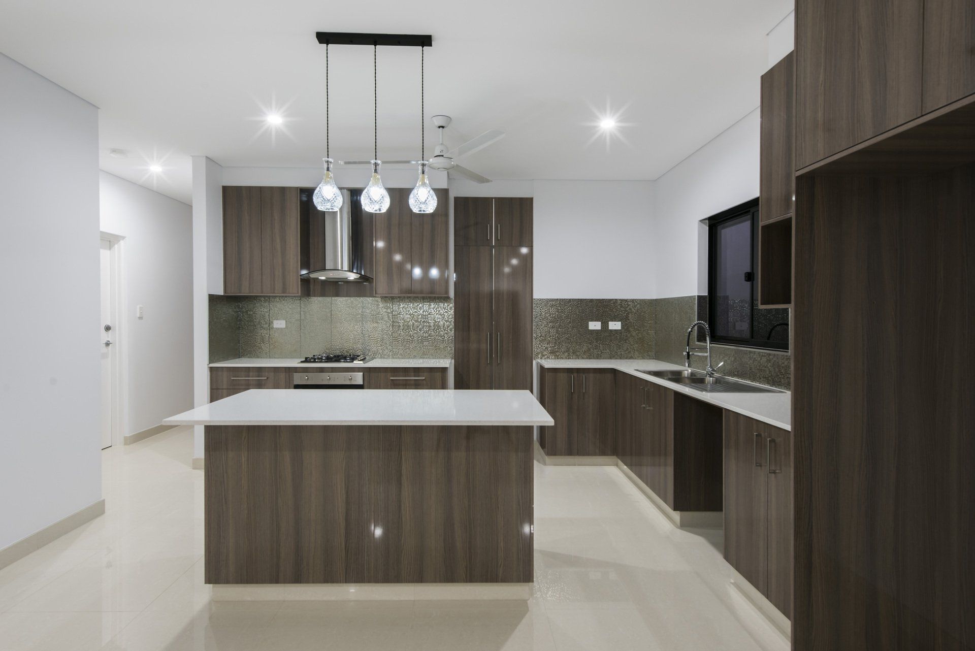 An empty kitchen with wooden cabinets and a large island.